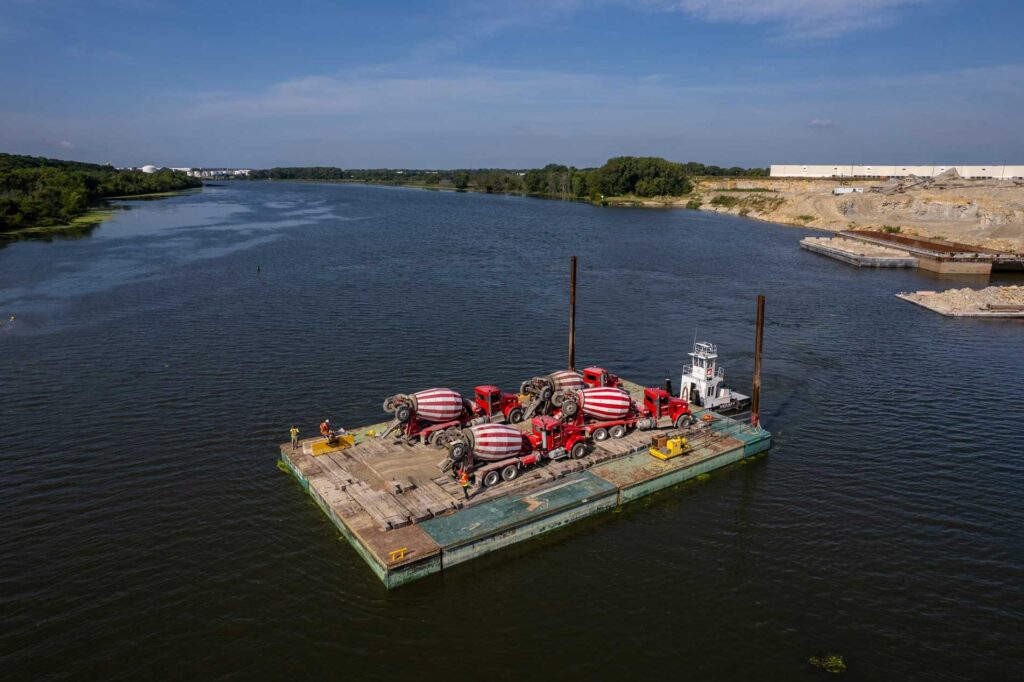 concrete mixers on barge going across river